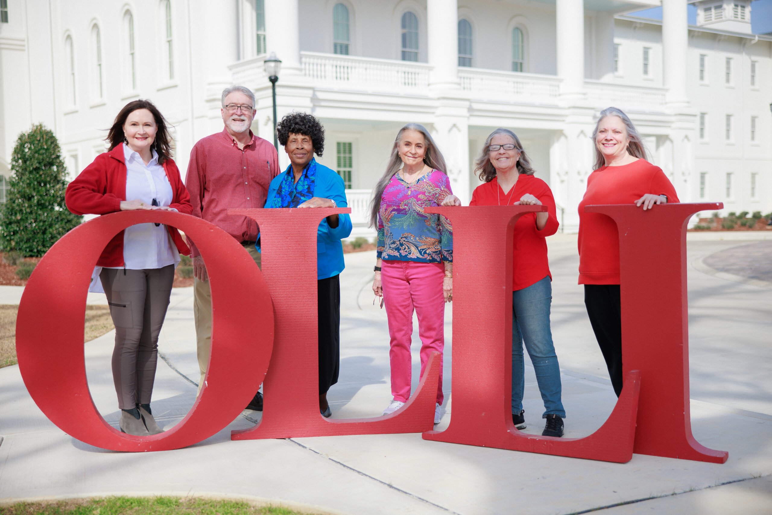 A group of OLLI members holding the letters O-L-L-I